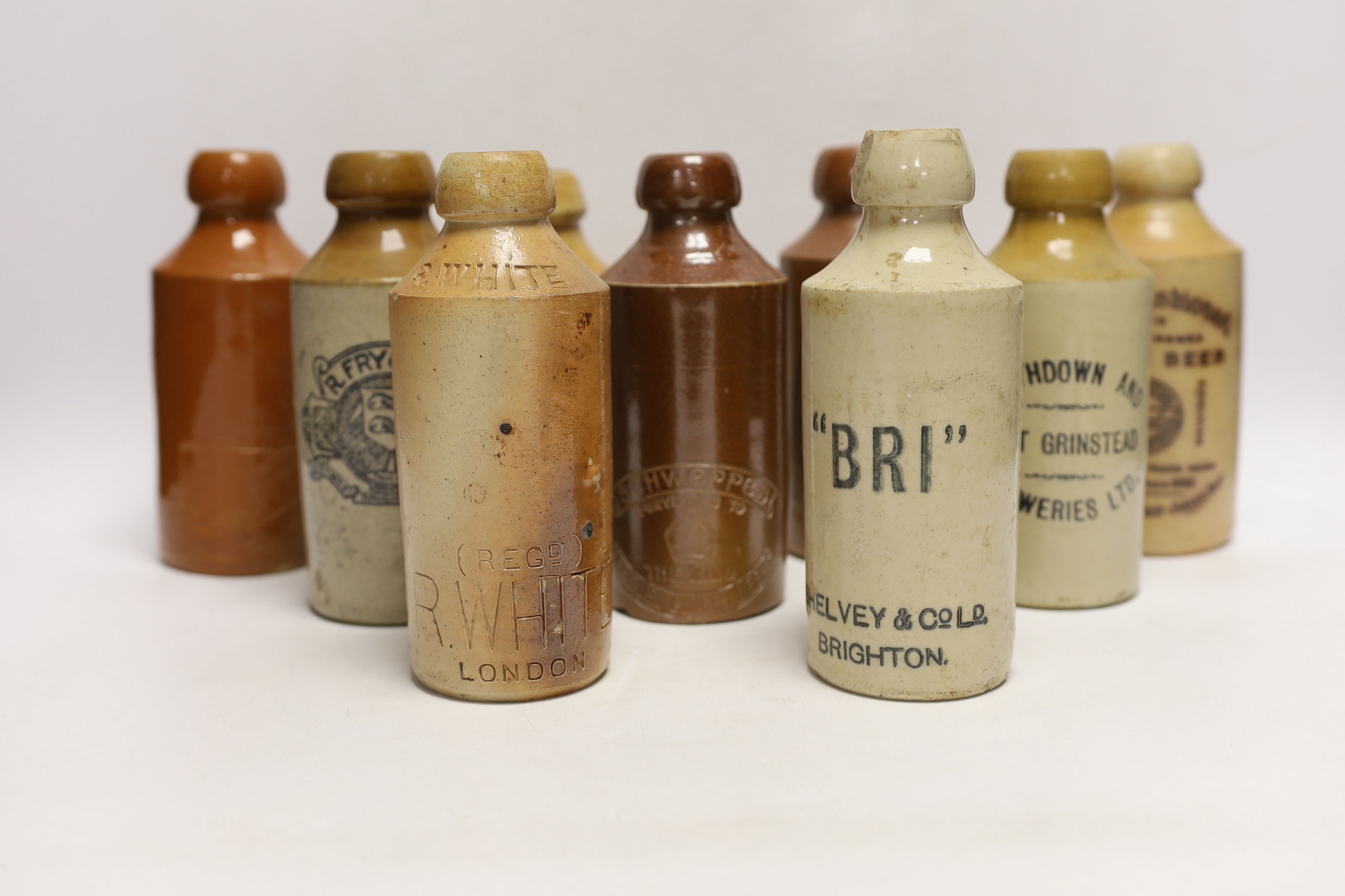 Early 20th century stoneware ginger beer bottles, two of Brighton, one of London, one of East Grinstead and four others